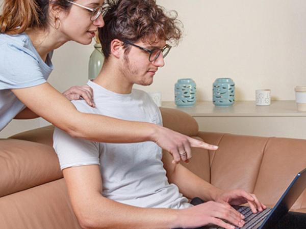 Two people using a laptop