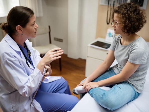 young person sitting with a medical professional