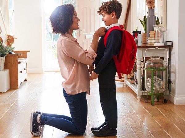 Image of a mum helping her little boy with his school uniform