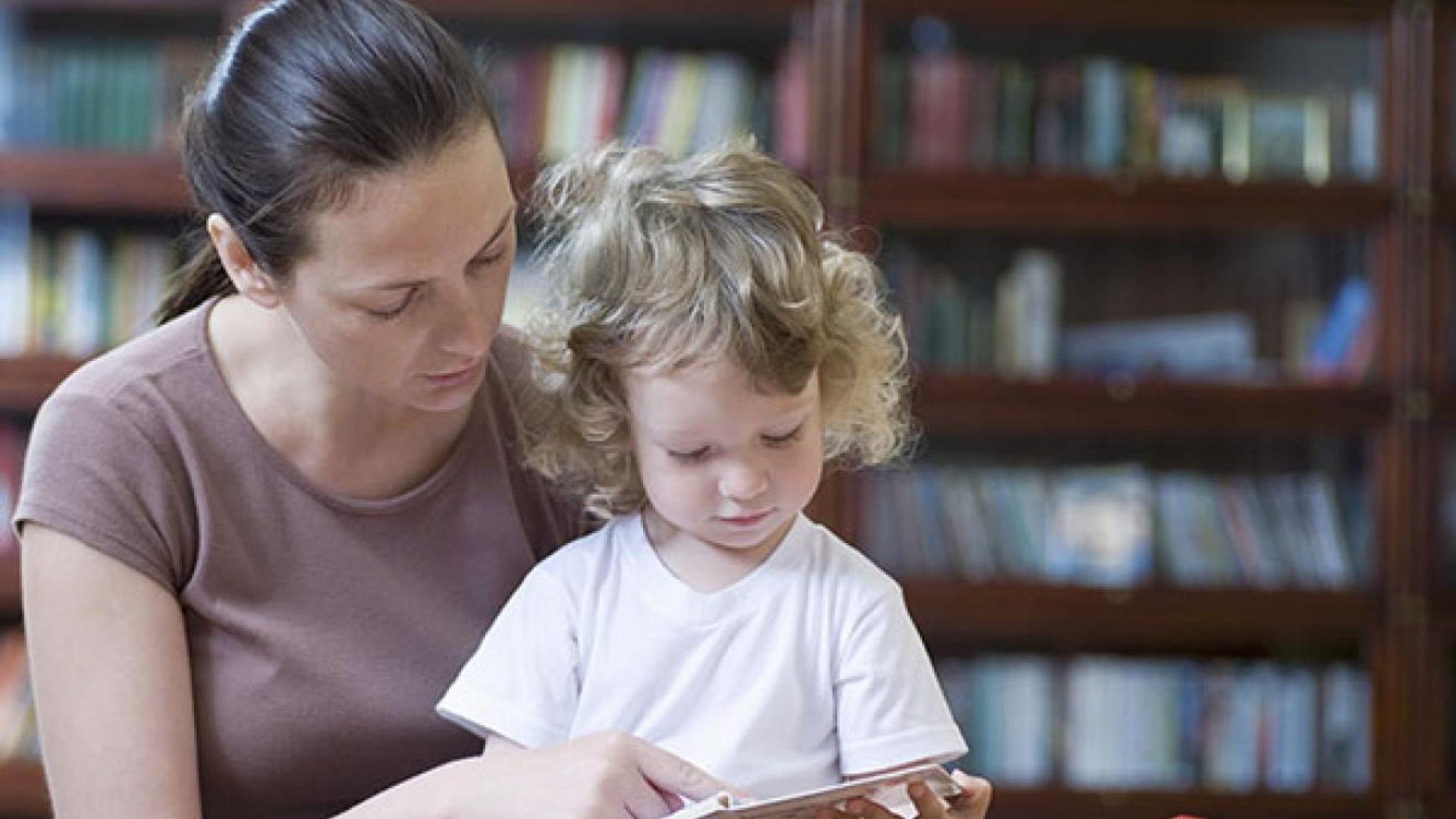 Picture of a 'mum' with her young child sat together reading